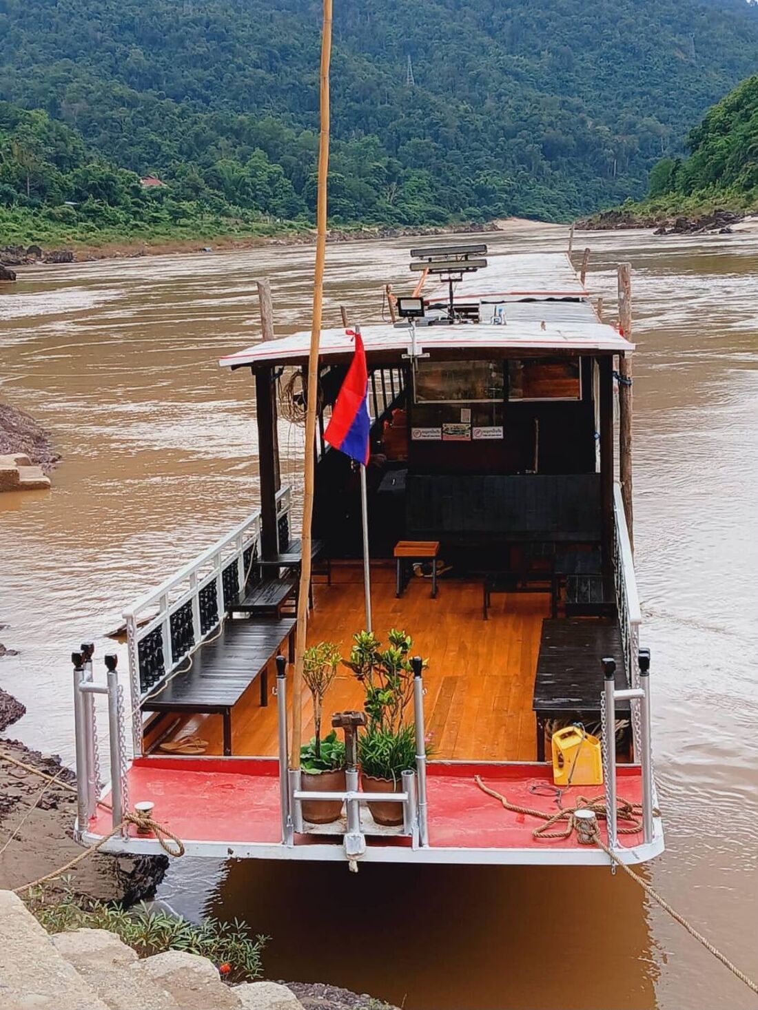 Open deck of the slow boat with the Lao flag