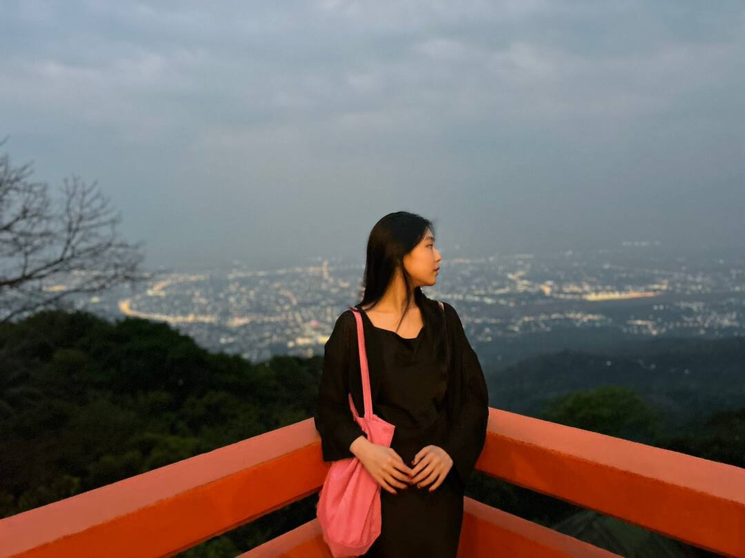 A guest watching the city lights at dusk