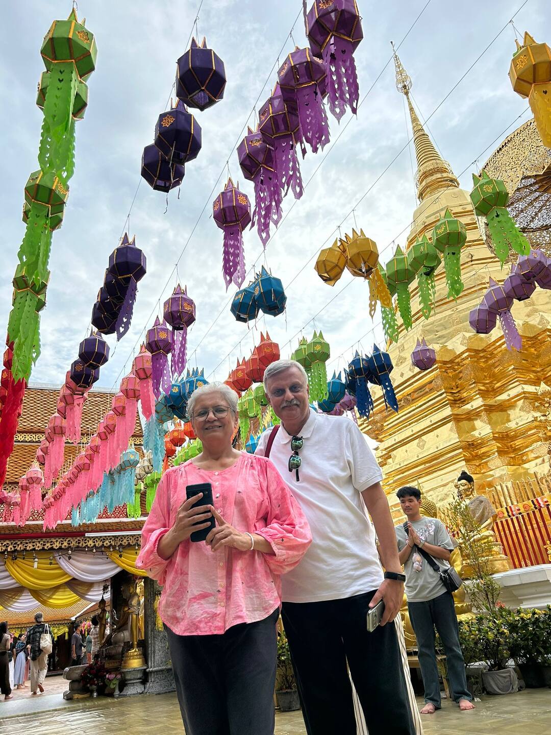 Guests under festival lanterns at a golden temple in Chiang Mai